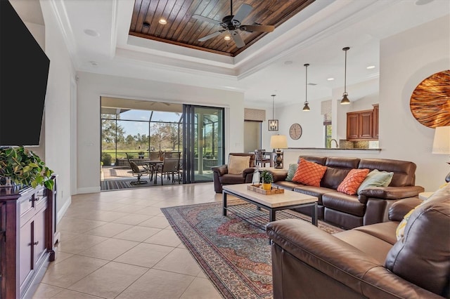 living room featuring light tile patterned floors, a raised ceiling, and crown molding