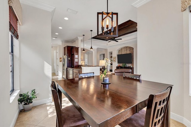 dining space with sink, light tile patterned floors, an inviting chandelier, and crown molding