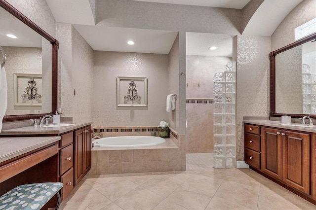 bathroom featuring plus walk in shower, vanity, and tile patterned flooring