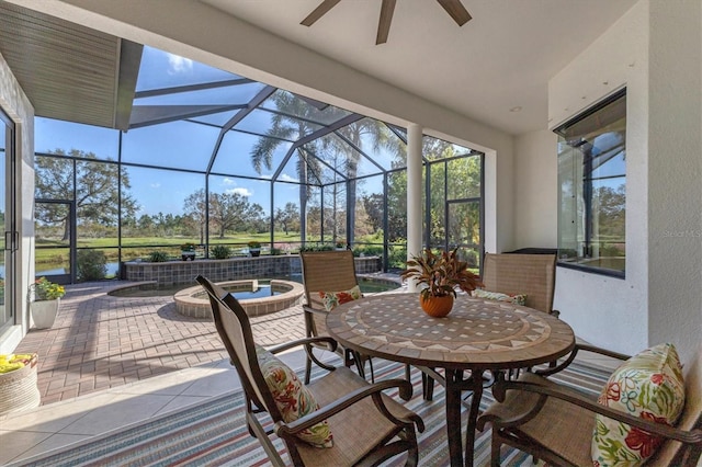 view of patio / terrace featuring ceiling fan, a water view, and a lanai