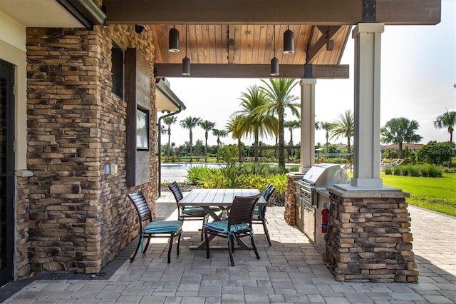 view of patio with area for grilling and a grill