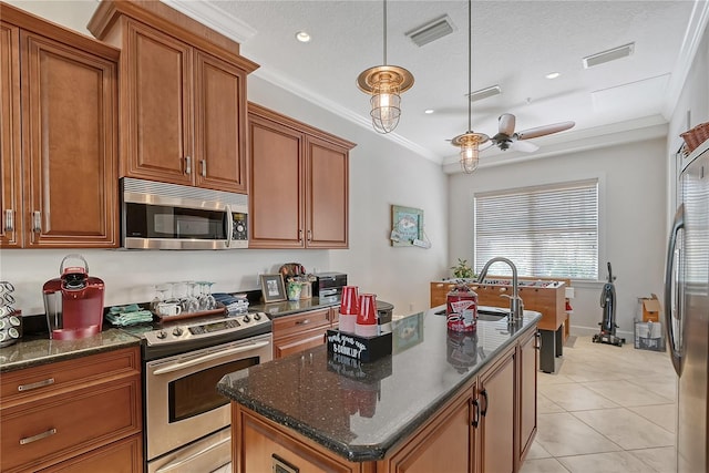 467 Canal Rd Unit 467, Sarasota, FL 34242 - kitchen with appliances with stainless steel finishes, brown cabinetry, an island with sink, a ceiling fan, and a sink