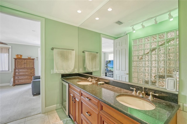 467 Canal Rd Unit 467, Sarasota, FL 34242 - ensuite bathroom featuring double vanity, tile patterned flooring, baseboards, recessed lighting, and crown molding