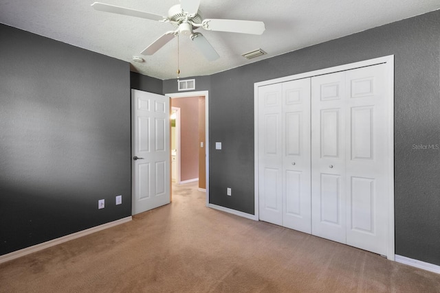 unfurnished bedroom with ceiling fan, light carpet, and a closet