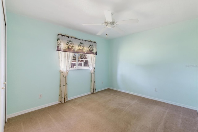 unfurnished room with ceiling fan and light colored carpet