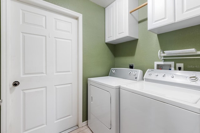 clothes washing area featuring cabinets and washing machine and clothes dryer