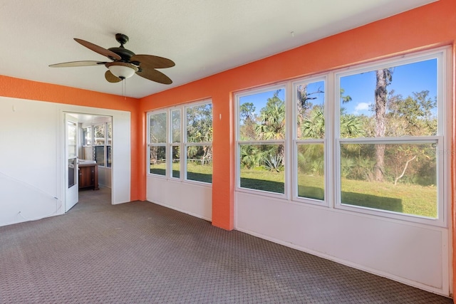 unfurnished sunroom with ceiling fan and plenty of natural light