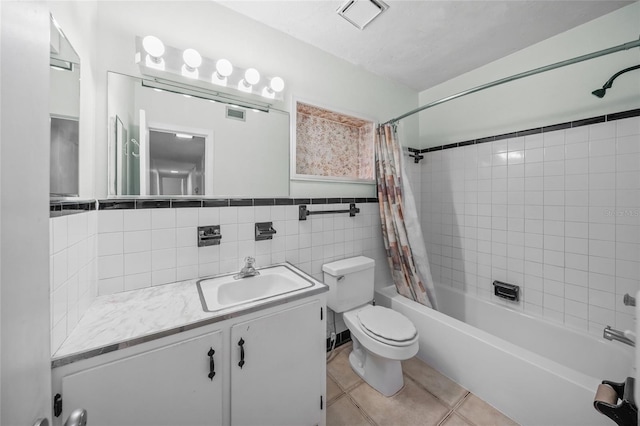 full bathroom featuring shower / tub combo, tile patterned floors, toilet, vanity, and tile walls