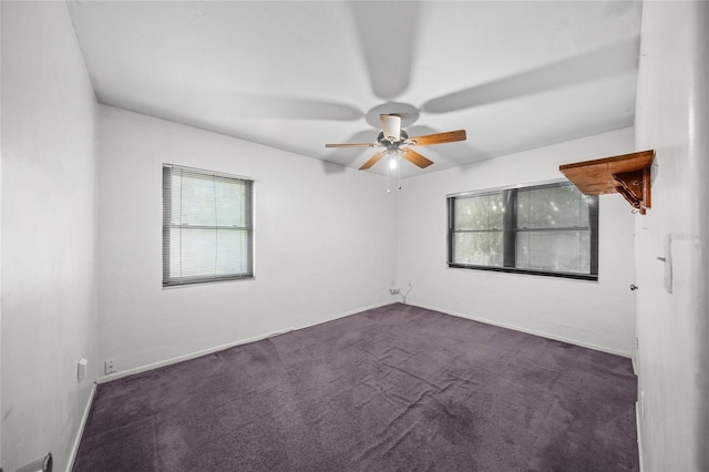 unfurnished room featuring dark colored carpet and ceiling fan