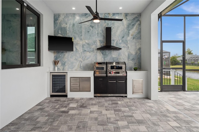 bar with ceiling fan, wall chimney range hood, beverage cooler, and tile walls