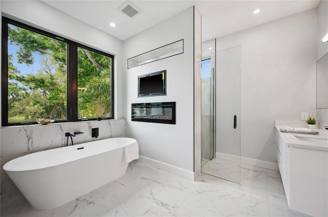 full bath with marble finish floor, recessed lighting, baseboards, a shower stall, and a soaking tub
