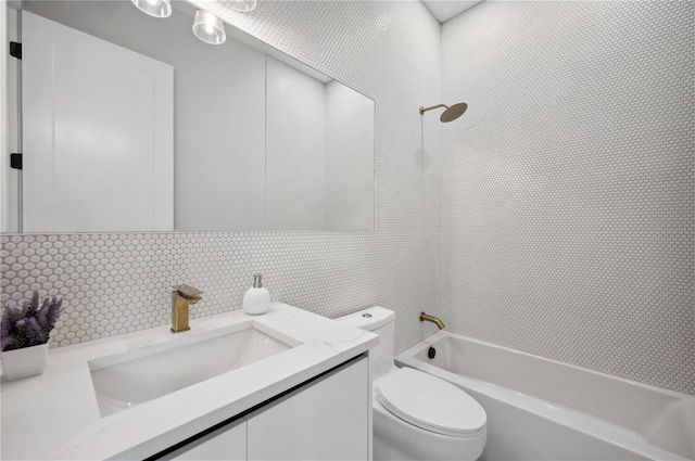 bathroom featuring vanity, toilet, tile walls, decorative backsplash, and shower / bathing tub combination