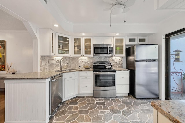 kitchen featuring white cabinets, sink, appliances with stainless steel finishes, and ornamental molding