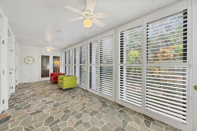 living area featuring ceiling fan and a textured ceiling