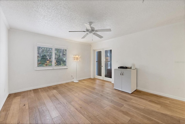 empty room featuring light wood-type flooring, a textured ceiling, and ceiling fan