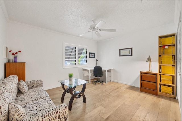 office featuring light wood-type flooring, a textured ceiling, ceiling fan, and crown molding