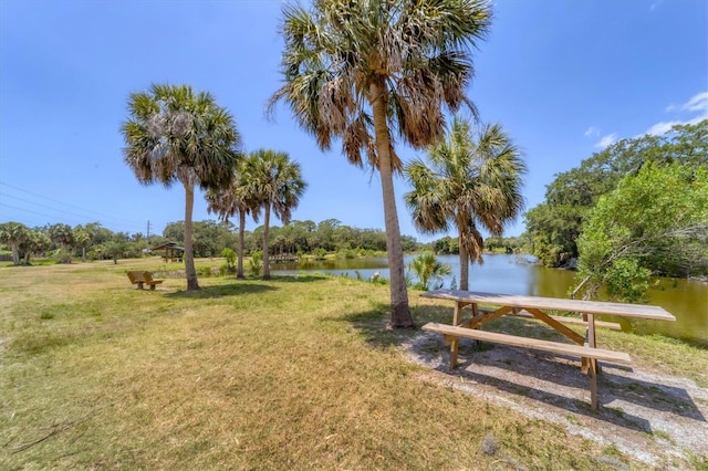 view of home's community featuring a water view and a lawn