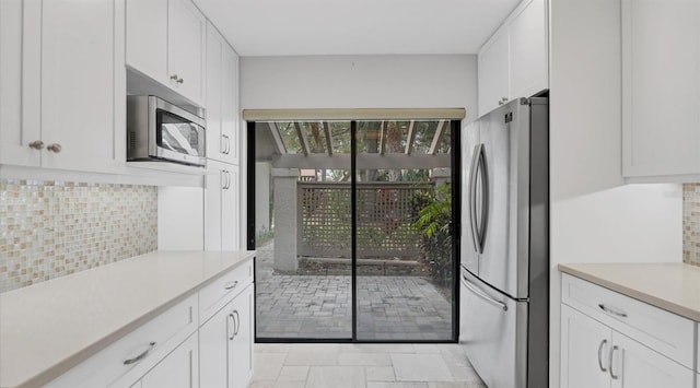 kitchen featuring tasteful backsplash, white cabinetry, and appliances with stainless steel finishes