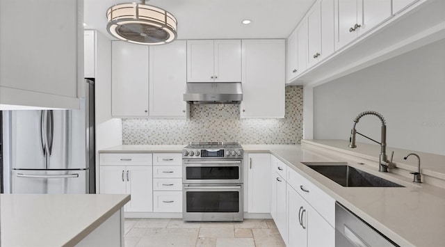 kitchen featuring white cabinetry, extractor fan, appliances with stainless steel finishes, backsplash, and sink