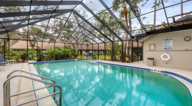 view of pool with glass enclosure and a patio area