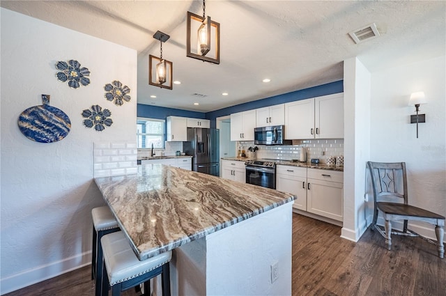 kitchen with white cabinets, kitchen peninsula, and stainless steel appliances