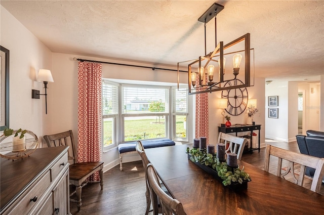 dining room featuring dark wood-type flooring, a chandelier, and a textured ceiling