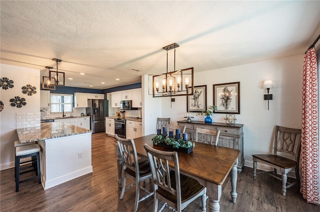 dining space featuring a textured ceiling, dark hardwood / wood-style floors, and sink