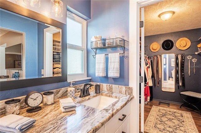 bathroom featuring hardwood / wood-style flooring, vanity, and a textured ceiling