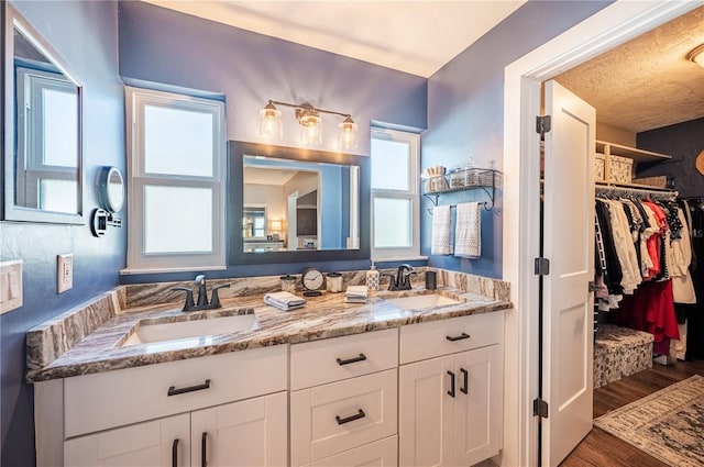 bathroom featuring wood-type flooring, a textured ceiling, and vanity