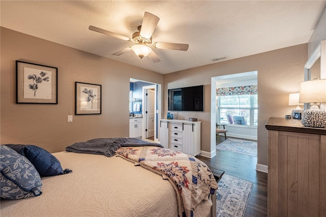 bedroom featuring dark wood-type flooring, ceiling fan, and ensuite bath