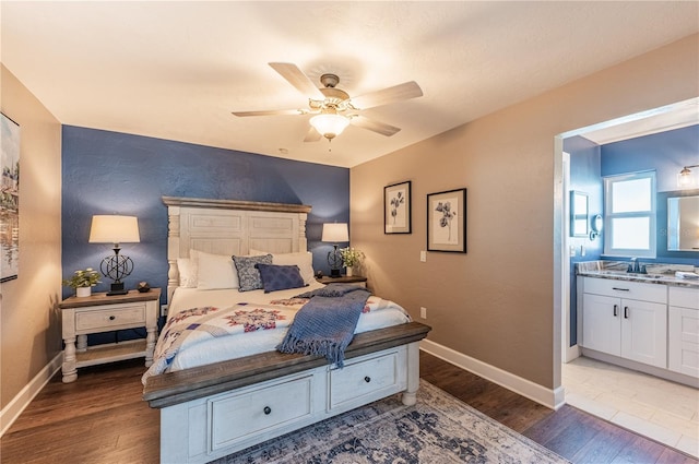 bedroom with hardwood / wood-style flooring, ceiling fan, ensuite bath, and sink