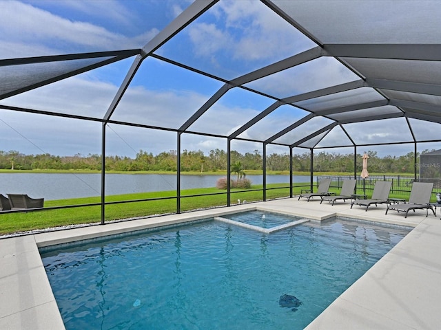 view of swimming pool with glass enclosure, a water view, a lawn, and a patio