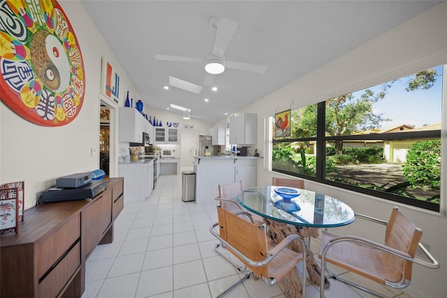 tiled dining space featuring lofted ceiling and ceiling fan