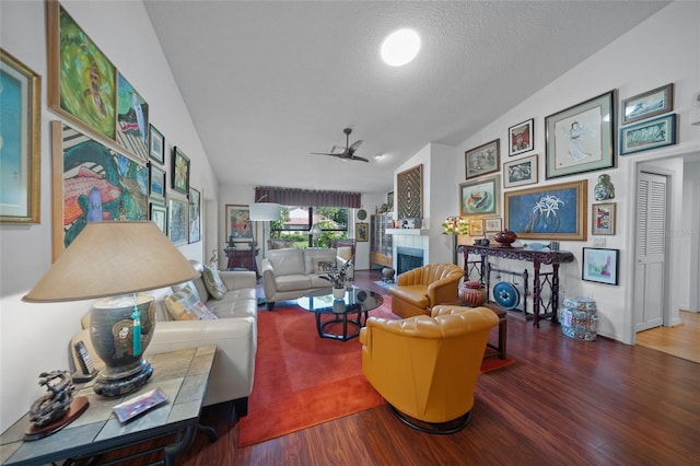 living room featuring a fireplace, lofted ceiling, a textured ceiling, and wood-type flooring