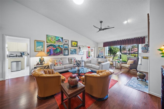 living room featuring ceiling fan, wood-type flooring, a textured ceiling, and high vaulted ceiling