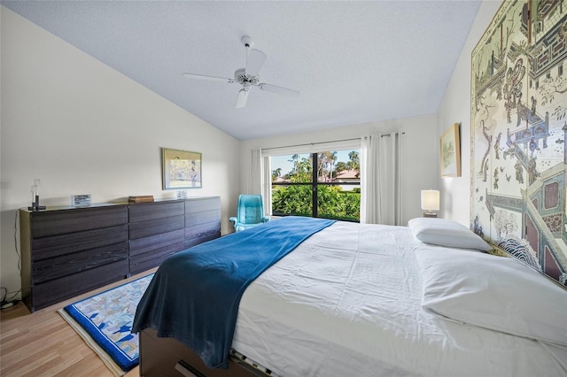 bedroom featuring hardwood / wood-style flooring, a textured ceiling, ceiling fan, and vaulted ceiling