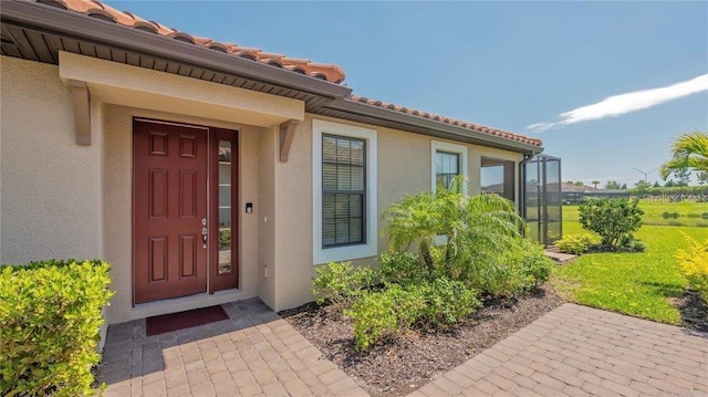 doorway to property with a lawn