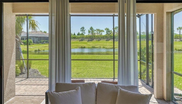 doorway to outside with a water view and a healthy amount of sunlight