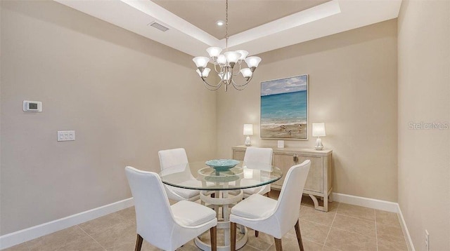 tiled dining room with a notable chandelier and a raised ceiling