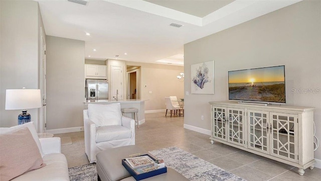 tiled living room with an inviting chandelier