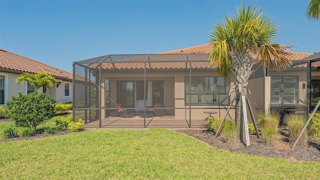 back of property featuring glass enclosure, a yard, and a patio area