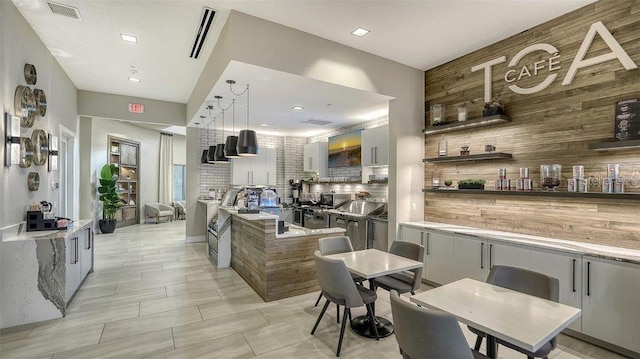 kitchen featuring white cabinets, hanging light fixtures, and tasteful backsplash