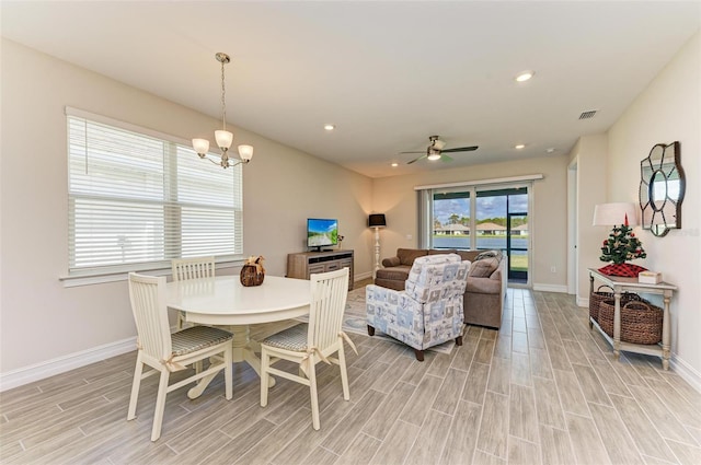 dining area featuring ceiling fan with notable chandelier and light hardwood / wood-style flooring