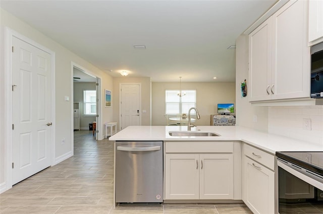 kitchen featuring stainless steel appliances, white cabinets, kitchen peninsula, sink, and pendant lighting