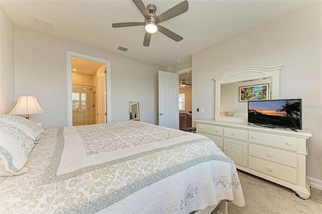 bedroom featuring ceiling fan, ensuite bath, and light colored carpet