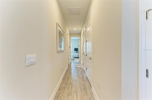 corridor with light hardwood / wood-style floors