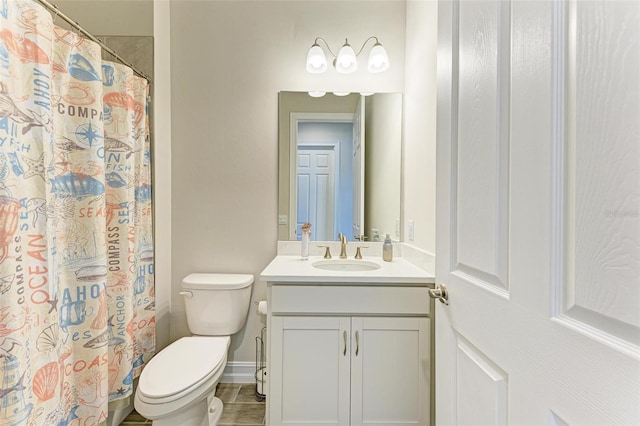 bathroom featuring curtained shower, vanity, and toilet