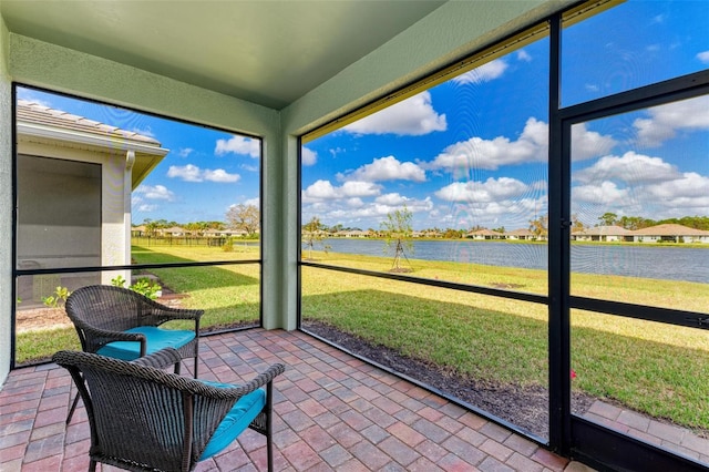 sunroom / solarium featuring a water view