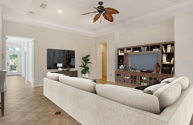 tiled living room with a raised ceiling and ceiling fan