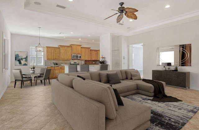 living room with ceiling fan, light tile patterned flooring, and a raised ceiling